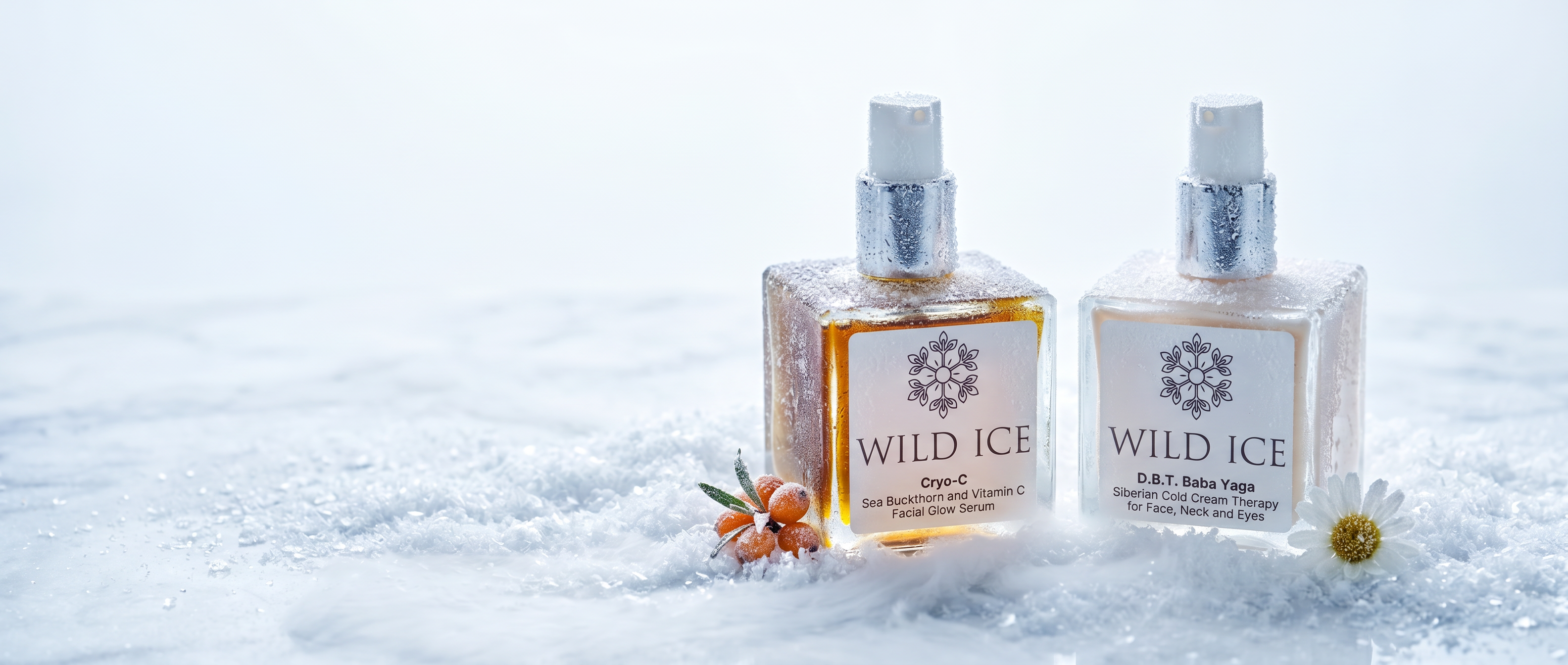 Two Wild Ice fragrance bottles, one with amber liquid and one clear with white liquid, standing in textured white snow with small orange and white flowers at their bases.