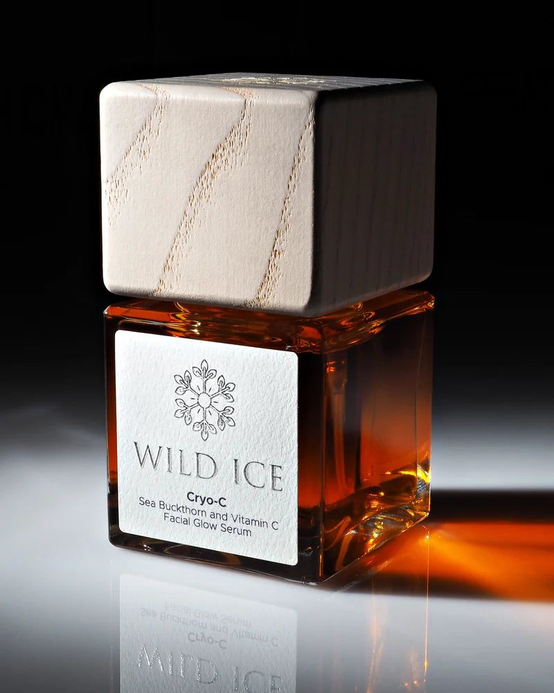Cryo-C serum in its cube glass bottle with wood cap, photographed in warm light