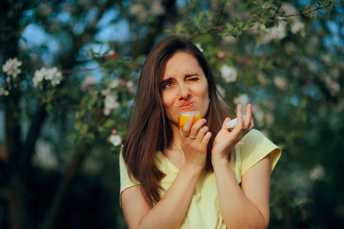 A woman wrinkling her nose at the smell of a face lotion