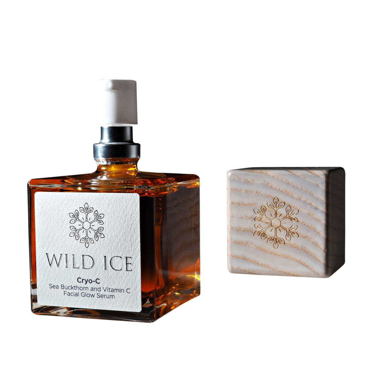 A bottle of Cryo-C vitamin C glow serum with its wood overcap set beside it, against a plain white background
