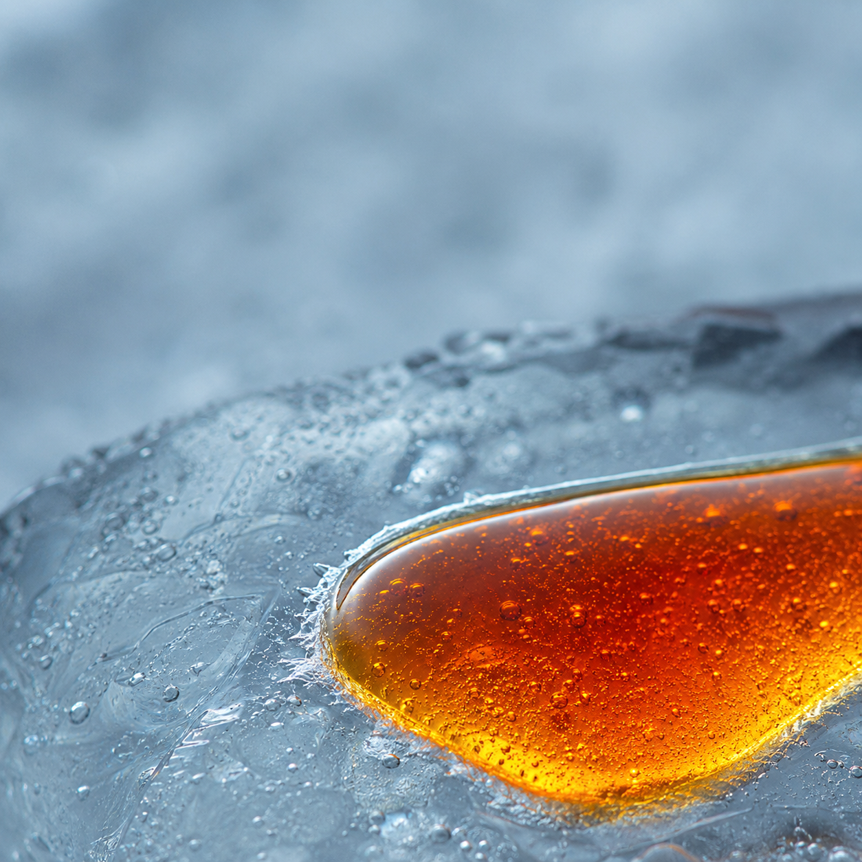 Macro of Cryo-C's crimson-amber vitamin C serum swatched on ice