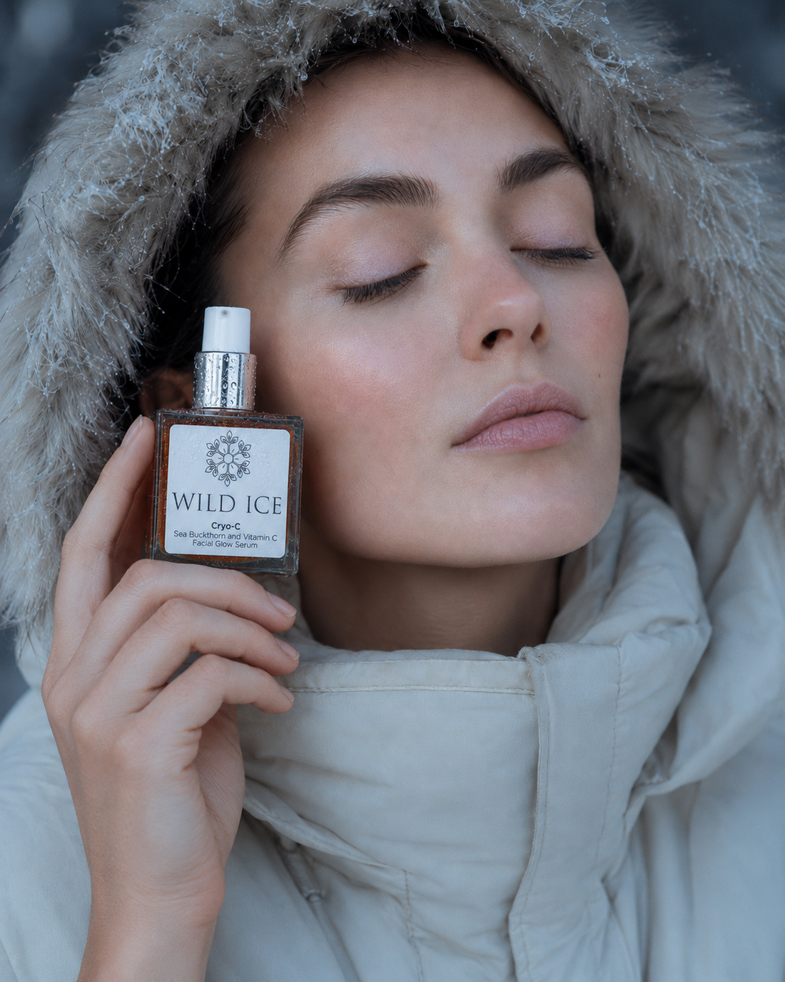 Model holding the Cryo-C vitamin C glow serum bottle to her cheek